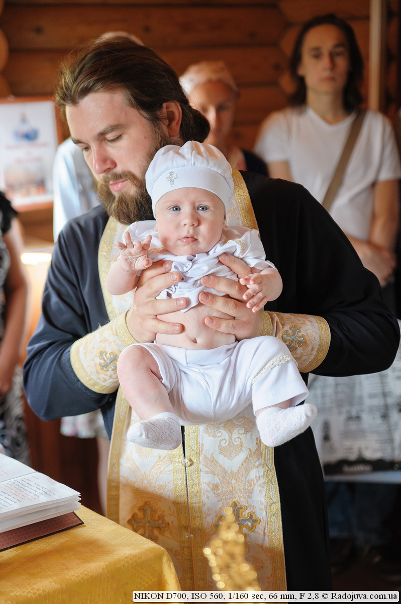 Священнослужитель часто берет ребенка на руки